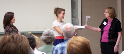 Hannah Westendorf receives her award from Joan O'Leary (right) while Hannah's mother watches.